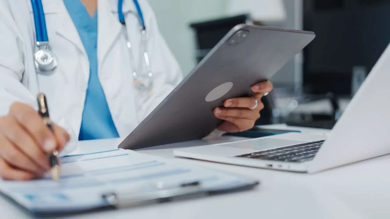Doctor using tablet and on computer