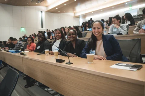 Medical students in a lecture in Geffen Hall smiling at the camera