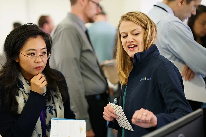 Two people collaborating in a busy room