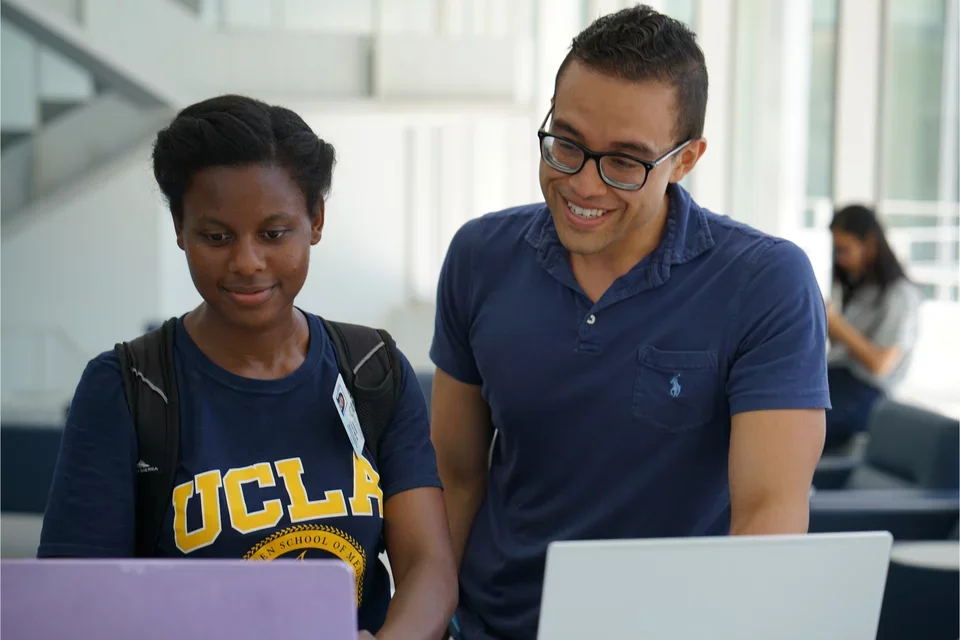 Two people working on their computers