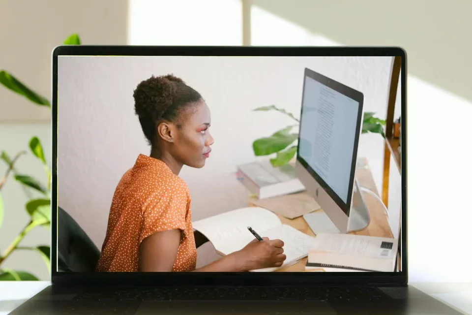 Girl looking at a computer on a laptop background.