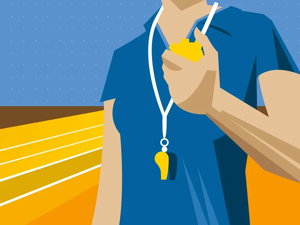 A person wearing a whistle and holding a timer on a race track