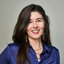 Kristen Lineberger smiling with a blue shirt on and gold jewelry